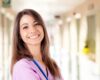 smiling qualified Spanish nurse in pink scrubs