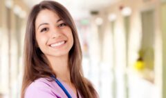 smiling qualified Spanish nurse in pink scrubs