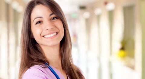 smiling qualified Spanish nurse in pink scrubs